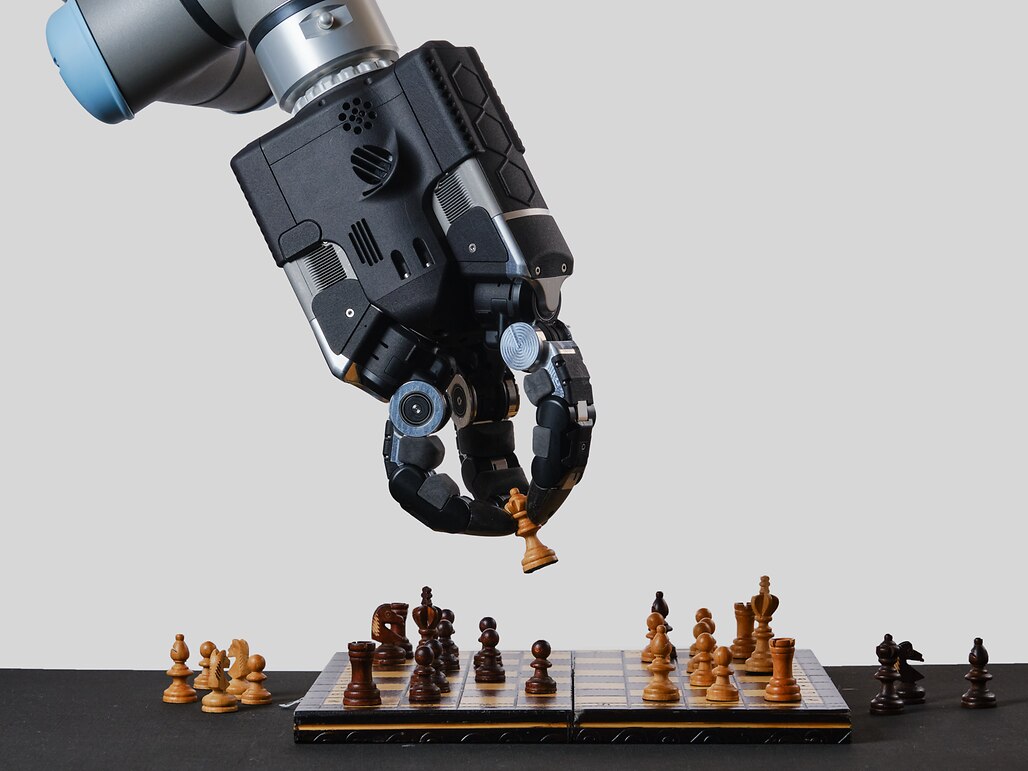 A robot playing chess, focused on the board as it strategizes its next move in the game.
